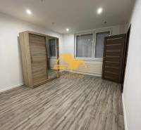 Prenajmem prerobený 1 izbový byt v Nových Zámkoch - Priestranná izba s posuvnou skriňou a podlahou s dreveným dekorom v 1-izbovom byte.