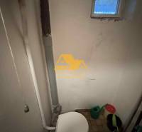 Predám rodinný dom s garážou v obci Dvory nad Žitavou - Kúpeľňa v rodinnom dome s toaletou a malým oknom, vedro a kanvica.