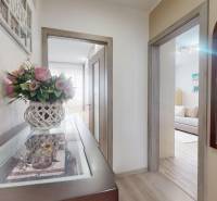 Vyššie už je nebo. 3izbový byt po kompletnej rekonštrukcii  - Chodba v 3-izbovom byte s kvetinovou dekoráciou a dreveným dekórom podlahy.