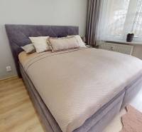 Vyššie už je nebo. 3izbový byt po kompletnej rekonštrukcii  - Spálňa v 3-izbovom byte s podlahou s dreveným dekorom, posteľou a prístupom na balkón.