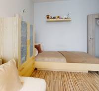 Vyššie už je nebo. 3izbový byt po kompletnej rekonštrukcii  - Izba s posteľou, skriňou a podlahou s dreveným dekorom v 3-izbovom byte.