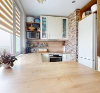 Vyššie už je nebo. 3izbový byt po kompletnej rekonštrukcii  - Kuchyňa v 3-izbovom byte so svetlou kuchynskou linkou a podlahou s dreveným dekorom.