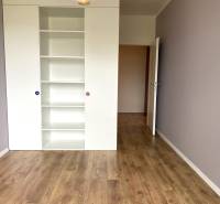 PRENÁJOM NÁDHERNÝ 3-IZBOVÝ BYT MAMAPAPA BA IV DÚBRAVKA - Izba s bielym regálom a podlahou s dreveným dekorom v 3-izbovom byte.