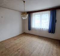 PREDAJ: Rodinný dom Kalameny s pozemkom 1.789m2 - Miestnosť v rodinnom dome s podlahou s dreveným dekorom, závesmi a lustrom.