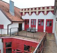 Prenájom kancelárie, Hauptstraße, Hauptstraße, Eisenstadt - Dvor s terasou a červenými dverami, obklopený architektúrou v Kanceláriách na Hauptstraße v Eisenstadte.