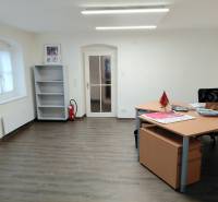 Prenájom kancelárie, Hauptstraße, Hauptstraße, Eisenstadt - Kancelárie s podlahou s dreveným dekorom, stolom a prázdnou policou.