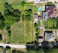 Stavebný pozemok 613m2 | Nitrianska Blatnica - Topoľčany - Letecký pohľad na pozemok pre bývanie v Nitrianskej Blatnici, lemovaný zeleňou.