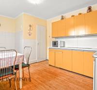 NA PREDAJ 4-IZBOVÝ RD NA VEĽKOM POZEMKU, VRAKÚŇ - Kuchyňa v rodinnom dome s oranžovými skrinkami a stolom na podlahe s dreveným dekorom.