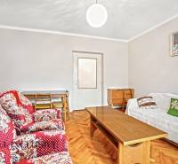 NA PREDAJ 4-IZBOVÝ RD NA VEĽKOM POZEMKU, VRAKÚŇ - Obývačka v rodinnom dome s červenými kreslami, dreveným stolíkom a podlahou s dreveným dekorom.