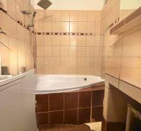 Predaj 2-izbového bytu v Krásne nad Kysucou - Kúpeľňa v 2-izbovom byte s rohovou vaňou a béžovými obkladačkami.