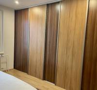 Prenájom 2-izb kompletne zariadený PET FRIENDLY byt BA II - Spálňa 2-izbového bytu s podlahou s dreveným dekorom a vstavanou skriňou.