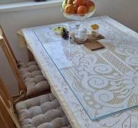 Prenájom 3 - izbový byt Bratislava - Petržalka - Jedálenský stôl v 3-izbovom byte s ovocnou misou a vzorovaným obrusom.