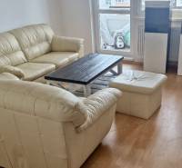 Prenájom 3 - izbový byt Bratislava - Petržalka - Sedacia súprava s podlahou s dreveným dekorom v obývačke 3-izbového bytu.