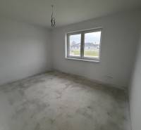 Novostavba rodinný dom Práznovce - Prázdna izba s veľkým oknom a nedokončenou podlahou v rodinnom dome.