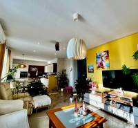 ,Predaj 4 izbový byt, 99 m2 + 30 m2 terasa,3 x parkovanie, BA II - Obývacia izba so žltou stenou a podlahou s dreveným dekorom v 4-izbovom byte.