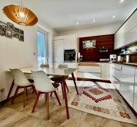 ,Predaj 4 izbový byt, 99 m2 + 30 m2 terasa,3 x parkovanie, BA II - Kuchyňa v 4-izbovom byte s dreveným dekorom a jedálenským stolom.