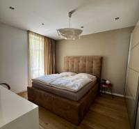 Prenájom veľkého luxusného 2izb bytu pri Bratislavskom hrade - Spálňa v 2-izbovom byte s posteľou a podlahou s dreveným dekorom.