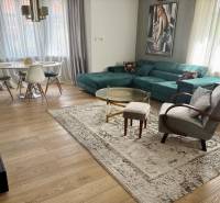 Prenájom veľkého luxusného 2izb bytu pri Bratislavskom hrade - Obývacia izba v 2-izbovom byte s podlahou s dreveným dekorom a elegantným nábytkom.