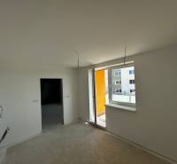 Predaj 3-izbového bytu len 15 minút od Bratislavy  - Nezariadená izba v 3-izbovom byte s balkónom a výhľadom na susedné budovy.