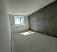 Predaj 3-izbového bytu len 15 minút od Bratislavy  - Izba v 3-izbovom byte s betónovou stenou a oknom.