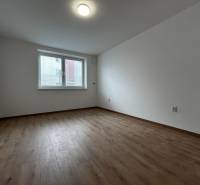 3-izbový byt v štandarde vrátane kuchyne len 15 minút od BA - Prázdna izba v 4-izbovom byte s podlahou s dreveným dekorom.