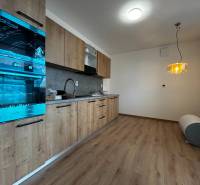 3-izbový byt v štandarde vrátane kuchyne len 15 minút od BA - Kuchyňa v 4-izbovom byte s podlahou s dreveným dekorom a zaveseným svietidlom.