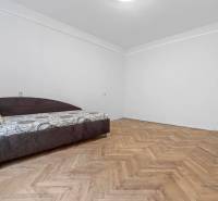 Predaj 4-izbový byt, 102m2, terasa 50m2, Bratislava-centrum, Gorkého - Izba s posteľou v 4-izbovom byte, podlaha s dreveným dekorom, svetlé steny.