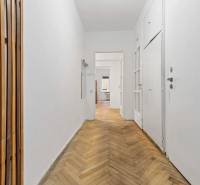 Predaj 4-izbový byt, 102m2, terasa 50m2, Bratislava-centrum, Gorkého - Chodba s bielymi stenami, podlahou s dreveným dekorom a drevenými lištami v 4-izbovom byte.