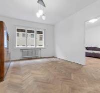 Predaj 4-izbový byt, 102m2, terasa 50m2, Bratislava-centrum, Gorkého - Obývacia izba v 4-izbovom byte s podlahou s dreveným dekorom a veľkým oknom.