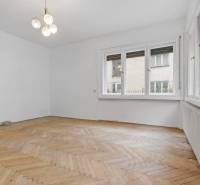 Predaj 4-izbový byt, 102m2, terasa 50m2, Bratislava-centrum, Gorkého - Priestranná miestnosť v 4-izbovom byte s oknami, svietidlom a podlahou s dreveným dekorom.