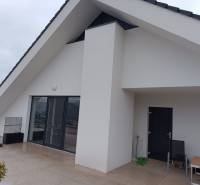 Štýlový 2-izbový byt s exkluzívnou terasou 102 m²  - Terasa s bielymi stenami a veľkými dverami, Nová Baňa, ulica Pod sekvojou.