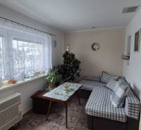 3 IZBOVÝ RODINNÝ DOM S GARÁŽOU, VEĽKÉ OZOROVCE - Obývacia izba v rodinnom dome s gaučom, stolom a oknom so záclonou.