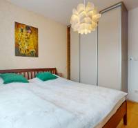 4i byt s atmosférou domu, terasou a parkovaním | Vrakuňa, 129m2 - Spálňa v 4-izbovom byte s obrazom na stene a podlahou s dreveným dekorom.