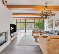 Nadštandardná 6-izbová vila v prominentnej lokalite - Interiér vily s krbom, drevenými trámami a veľkými oknami, útulné sedacie kúty.