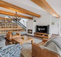 Nadštandardná 6-izbová vila v prominentnej lokalite - Obývacia izba vily s knižnicou, sedacou súpravou a krbom, prepojená s jedálňou.