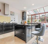 Nadštandardná 6-izbová vila v prominentnej lokalite - Štýlová kuchyňa vo vile so zariadením a presklenou jedálňou plnou prirodzeného svetla.