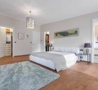 Nadštandardná 6-izbová vila v prominentnej lokalite - Spálňa vo vile s bielou posteľou, šatníkom a kúpeľňou s kruhovým zrkadlom.