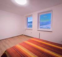 ‼️  PRENÁJOM  - 2 IZBOVÉHO BYTU, PARTIZÁNSKE SÍDLISKO ŠÍPOK ‼️ - Svetlá izba s dvoma oknami, posteľou a podlahou s dreveným dekorom.