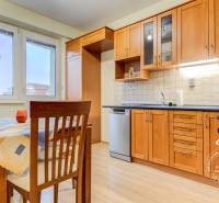 2-izbový byt v NOVOSTAVBE, klíma, balkón, Kazanská ul. - Kuchyňa s drevenými skrinkami, jedálenským stolom a podlahou s dreveným dekorom v 2-izbovom byte.