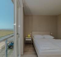 POVLJANA - dvojizbový apartmán D3 - 1. rad k moru - Spálňa v Rekreačnom apartmáne s výhľadom, posteľou a podlahou s dreveným dekorom.