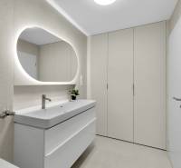 I Na predaj zrekonštruovaný 4i byt v Ružinove, Miletičova - Kúpeľňa so svetlým umývadlom, oválnym zrkadlom a úložným priestorom v 4-izbovom byte.