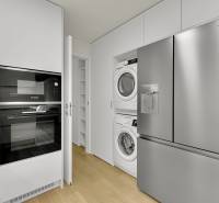 I Na predaj zrekonštruovaný 4i byt v Ružinove, Miletičova - Kuchyňa v 4-izbovom byte s práčkou, sušičkou, rúrou a chladničkou, podlaha s dreveným dekorom.