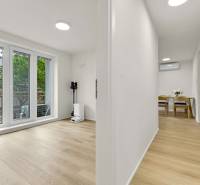 I Na predaj zrekonštruovaný 4i byt v Ružinove, Miletičova - Interiér 4-izbového bytu s podlahou s dreveným dekorom a presklenými dverami.