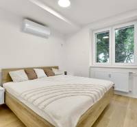 I Na predaj zrekonštruovaný 4i byt v Ružinove, Miletičova - Spálňa v 4-izbovom byte s dvojlôžkom, klimatizáciou a podlahou s dreveným dekorom.