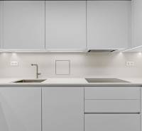 I Na predaj zrekonštruovaný 4i byt v Ružinove, Miletičova - Minimalistická kuchyňa s bielou linkou a vstavanými spotrebičmi v 4-izbovom byte.