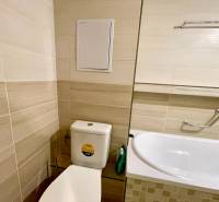 Predáj 1i čiastočne zrekonštruovaný byt s loggiou - Kúpeľňa v 1-izbovom byte so svetlým obkladom, WC a vaňou s držiakom.