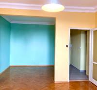 Predáj 1i čiastočne zrekonštruovaný byt s loggiou - 1-izbový byt s farebnými stenami a podlahou s dreveným dekorom.