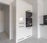 I PREDAJ novostavba 4i rodinného domu s terasou a záhradkou - Kuchynská linka v rodinnom dome s bielymi skriňami a čiernymi úchytkami.