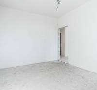 I NA PREDAJ 4i rodinný dom s veľkým pozemkom v Galante - Prázdna miestnosť s bielymi stenami a betónovou podlahou v rodinnom dome.