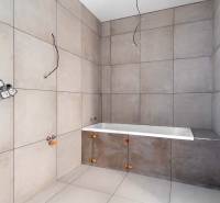 I NA PREDAJ 4i rodinný dom s veľkým pozemkom v Galante - Kúpeľňa v rodinnom dome s veľkými svetlosivými obkladačkami a neosadenou vaňou.